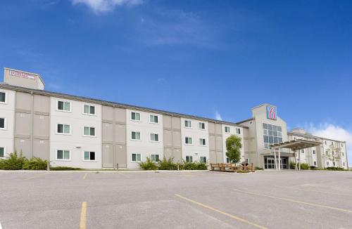 a large building with a parking lot in front of it at Motel 6-Brandon, MB in Brandon