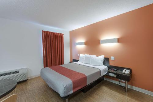 a hotel room with a large bed and a table at Motel 6-Brandon, MB in Brandon