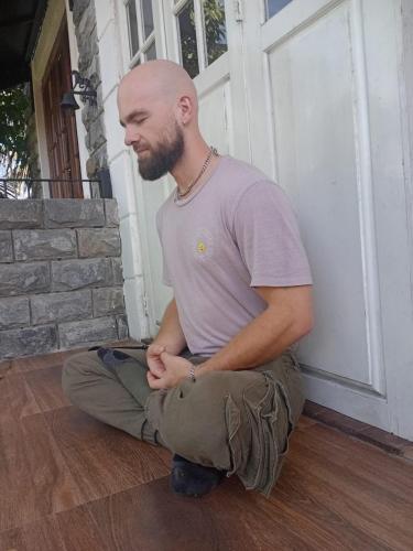 a man sitting on the floor in front of a door at Teirack Rosis Wish in Kandy