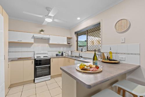 a kitchen with a table with a plate of fruit on it at Family-Friendly 3 Bedroom Home in Hervey Bay in Pialba