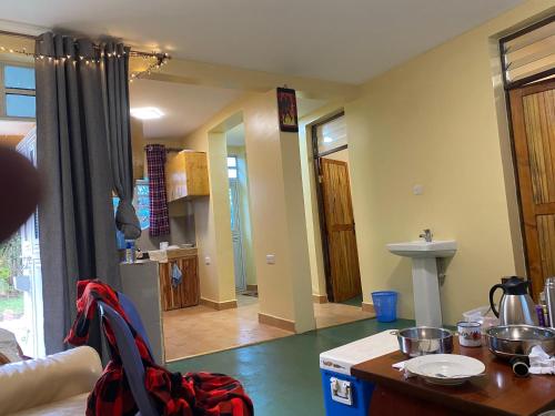 a room with a kitchen and a living room at Oloiba Nkuti lodge in Sekenani