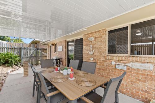 a wooden table and chairs on a patio at Family-Friendly 3 Bedroom Home in Hervey Bay in Pialba