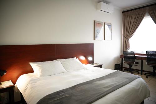 una camera da letto con un letto grande e una scrivania di Amohela Guesthouse a Midrand