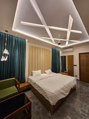 ein Schlafzimmer mit einem großen Bett und einem grünen Sofa in der Unterkunft Kurunchi Malar Resorts in Hosur