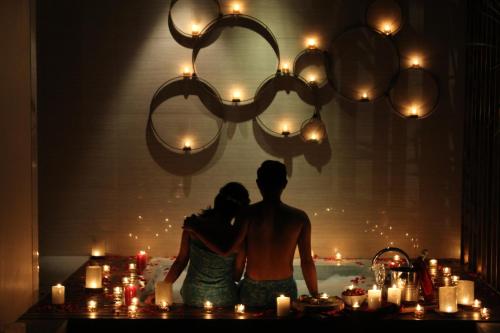 a man and woman standing in front of a table with candles at Berry Amour Romantic Villas in Seminyak