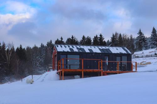 een huis met sneeuw op het dak in de sneeuw bij Domek Jak z Obrazka in Sierpnica