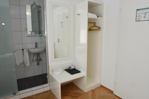 La salle de bains est pourvue d'un lavabo et d'un miroir. dans l'établissement Badischer Landgasthof Hirsch, à Hügelsheim