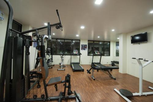 a gym with several tread machines in a room at Budget Inn Service Apartments - Tiger Plaza in Vengni