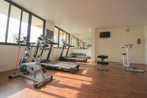 a gym with three exercise bikes and a television at Budget Inn Service Apartments - Tiger Plaza in Vengni
