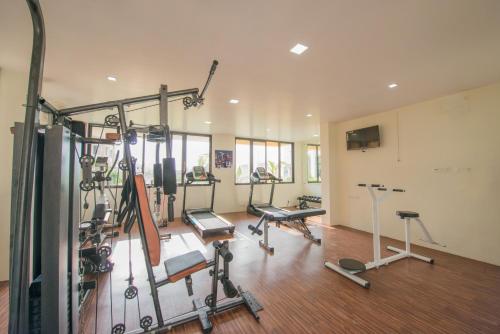 a gym with several treadmills and exercise bikes at Budget Inn Service Apartments - Tiger Plaza in Vengni