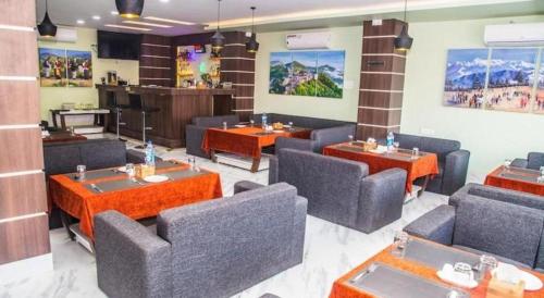 a restaurant with couches and tables in a room at Hotel Gajur Palace in Dharān Bāzār