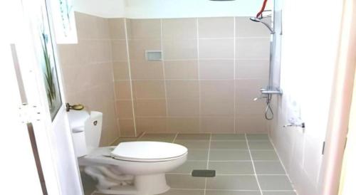 een kleine badkamer met toilet en douche bij Alexis Cliff Dive Resort in San Agustin