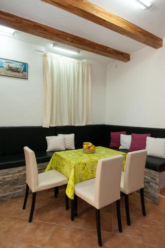 a dining room with a table with a yellow table cloth at Apartment Tomic A-5 in Lovran