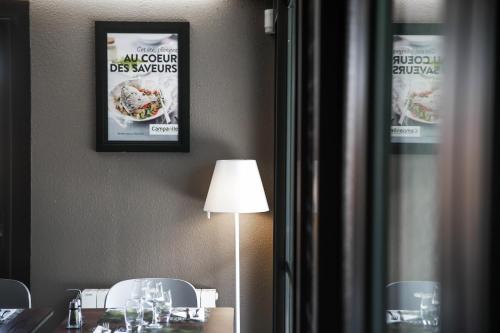 a dining room with a table with a lamp and a picture at Campanile Rennes Ouest Cleunay in Rennes