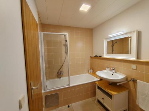 a bathroom with a tub and a sink and a shower at Grünerbalkon Ferienappartement in Klagenfurt
