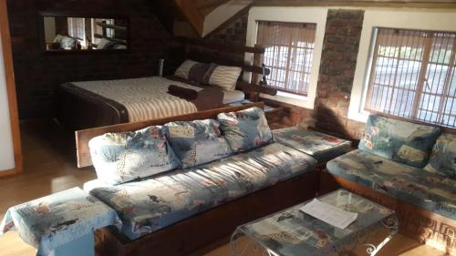 a living room with a couch and a bed at Do Drop In in Hoedspruit