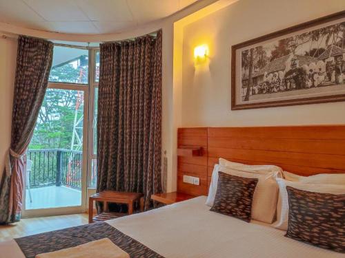 a bedroom with a bed and a large window at Kandy krush Hotel in Kandy