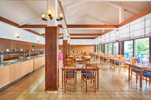 comedor con mesas y sillas de madera en Apartments Kanegra Plava Laguna en Umag