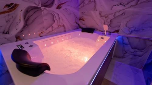 a bath tub in a room with a rock wall at MagicSpa Gold in Chilly-Mazarin