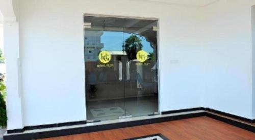 een glazen deur van een gebouw met gele borden erop bij Hotel Glee in Challi