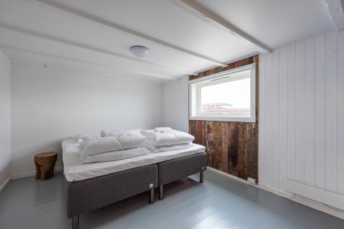 a bedroom with a bed in a room with a window at Hattvika Lodge in Ballstad