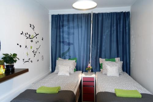 トゥルクにあるApartment Turku City Centerのベッドルーム1室(ベッド2台、青いカーテン付きの窓付)