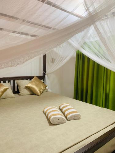 a white bed with two pillows on it at Rithu villa in Hikkaduwa
