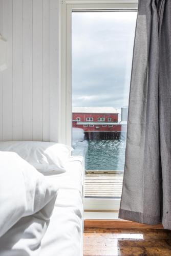 a bedroom with a bed and a window with a view at Hattvika Lodge in Ballstad