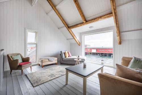 a living room with a couch and chairs and a table at Hattvika Lodge in Ballstad