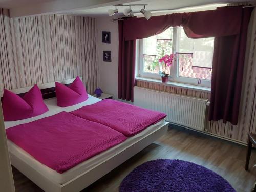 een slaapkamer met een paars bed met paarse kussens bij Ferienhaus Scheper in Bad Frankenhausen