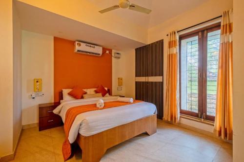 a bedroom with a large bed and a large window at Celeste holiday homes in Calangute