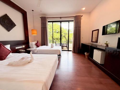 pokój hotelowy z dwoma łóżkami i dużym oknem w obiekcie The Moon w Siem Reap
