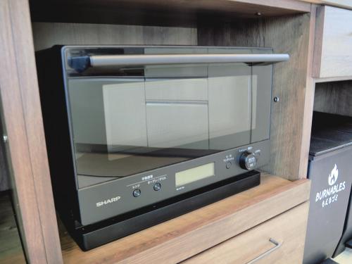 a microwave oven sitting on top of a shelf at Yamatsu Tokyo House in Tokyo