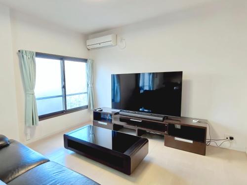 a living room with a large flat screen tv at Yamatsu Tokyo House in Tokyo