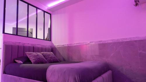 a purple room with a bed and a window at MagicSpa91 in Chilly-Mazarin