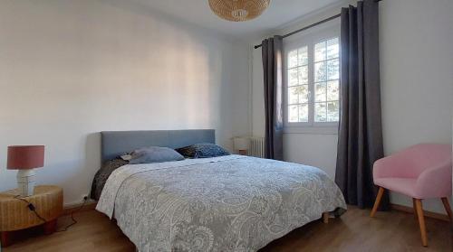 a bedroom with a bed and a pink chair at T3 indépendant Villa Heas in Argelès-Gazost