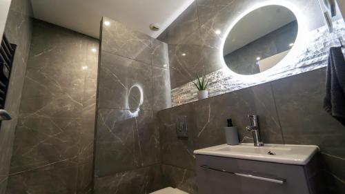 a bathroom with a sink and a mirror at MagicSpa91 in Chilly-Mazarin