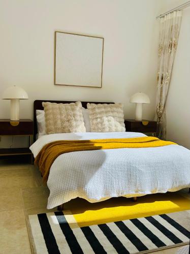 a bedroom with a large bed with a yellow and white blanket at Private Rm in a Stylish Chatswood Home Near Station in Sydney