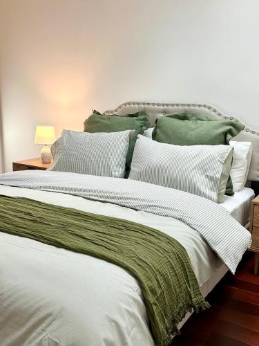 a large white bed with green and white pillows at Private Rm in a Stylish Chatswood Home Near Station in Sydney