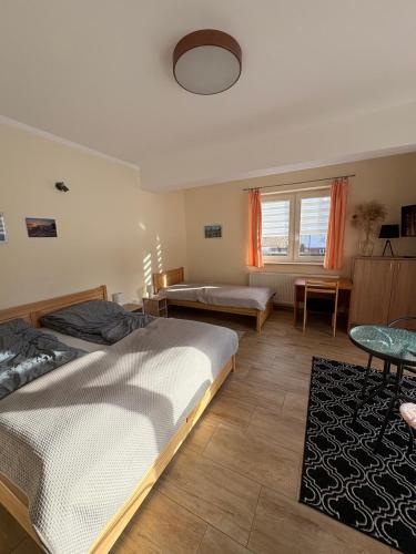 a bedroom with two beds and a table at KAJA Zawoja in Zawoja