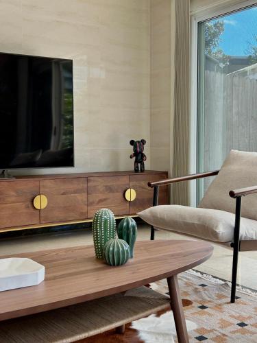 a living room with a tv and a coffee table at Private Rm in a Stylish Chatswood Home Near Station in Sydney