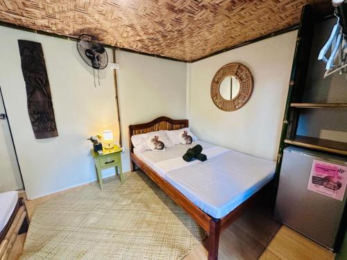a small bedroom with a bed and a mirror at The Green House Port Barton in San Vicente