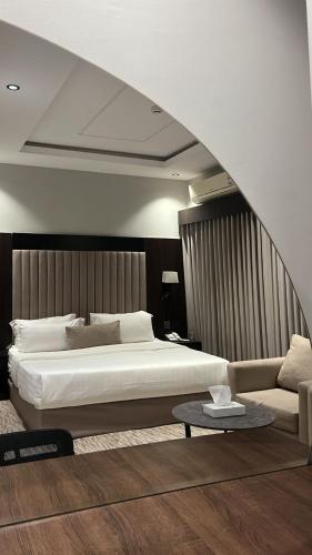 a bedroom with a large bed and a couch at شقق البندقية للشقق المخدومة Albundaqia serviced apartments in Riyadh