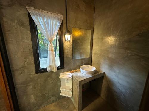 a bathroom with a sink and a window at Ban Buarawong บ้านบัวระวงค์ in Ban Nong Faek