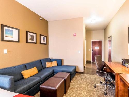 un soggiorno con un divano blu e una scrivania di Hawthorn Extended Stay by Wyndham Amarillo a Soncy