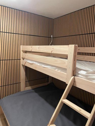 a bunk bed in a room with a wooden wall at Rez de jardin CABOURG in Cabourg