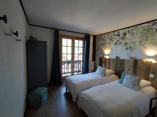 a hotel room with two beds and a window at Chalet Appart'Hôtel l'Eau Vive in Saint-Nicolas-la-Chapelle