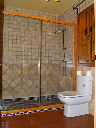 a bathroom with a toilet and a glass shower at Casa de Barro in Matarrubia