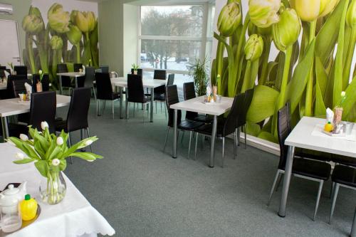 restauracja ze stołami, krzesłami i kwiatami na ścianie w obiekcie Hotel Boršičanka w Hawierzowie
