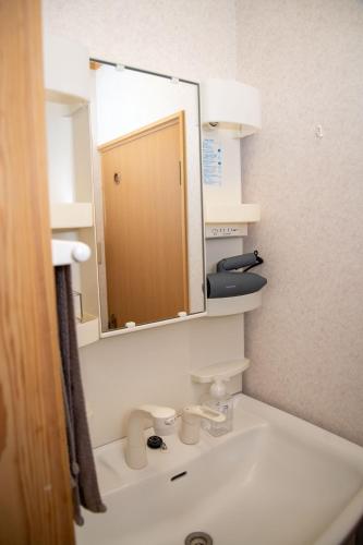 a bathroom with a sink and a mirror at 日田天ヶ瀬の源泉掛け流し温泉付き貸別荘 5名様まで同料金 in Hita